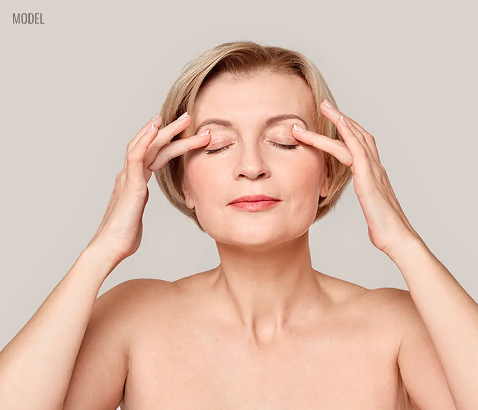 female closed eyes with both hand on her eyelid